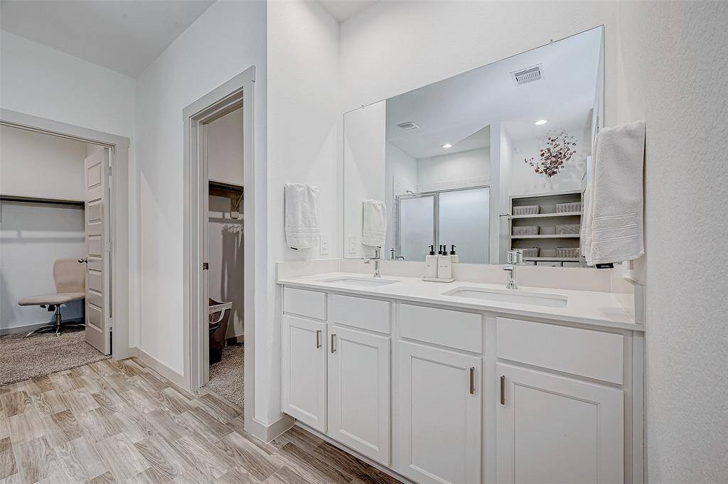 This bathroom features a dual-sinkvanity, while the large mirror reflectsthe light, creating a bright andconvenient space for daily grooming.