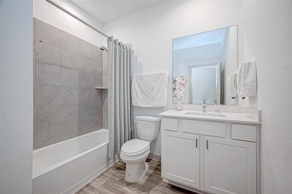 This bathroom features a clean andmodern design, with a tub/showercombination and a vanity, providing afunctional and stylish space for dailyroutines.