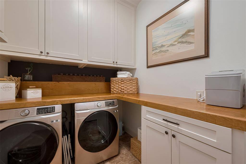 Laundry room with custom designed and built cabinets and storage, tile floors.