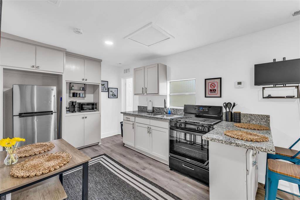 Modern kitchen with appliances, ample cabinetry, and granite countertops. Open layout with bright, neutral decor.