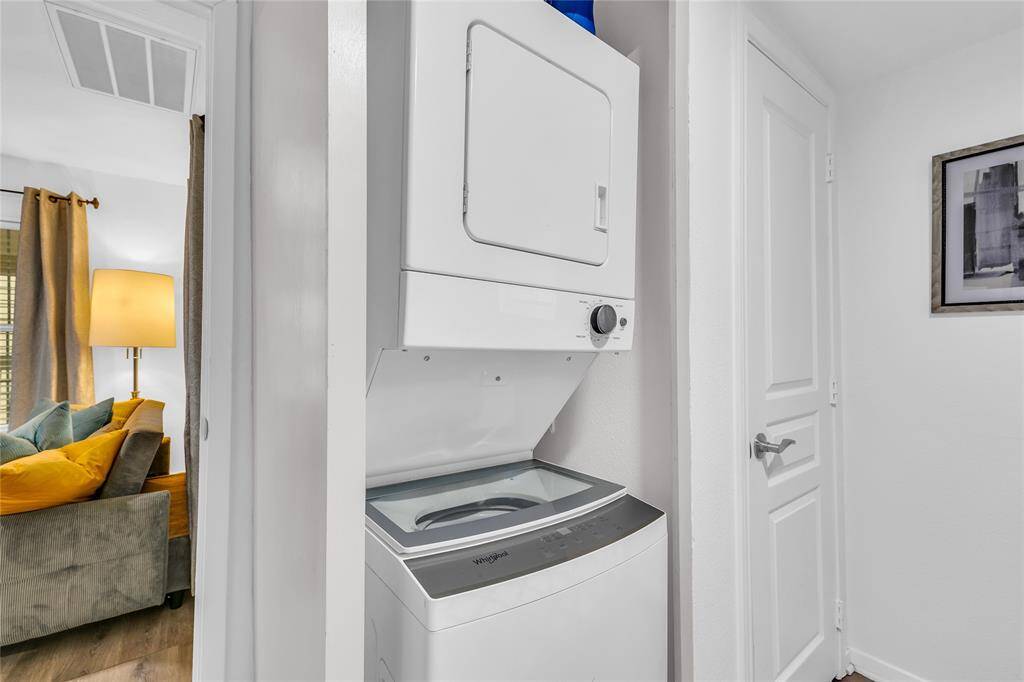 This photo showcases a compact laundry area with a stacked washer and dryer, offering a practical solution for home cleaning needs without sacrificing space.