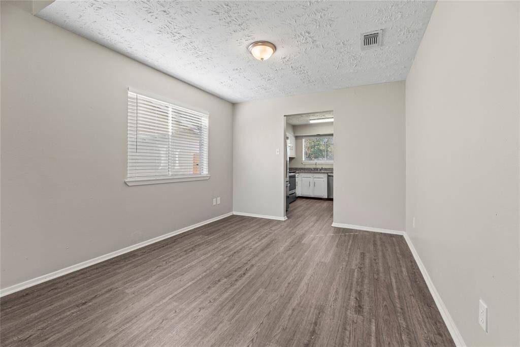The large dining area is perfect for a full-sized table and offers easy care floors, stylish paint, a large bright window, and easy access to the kitchen.