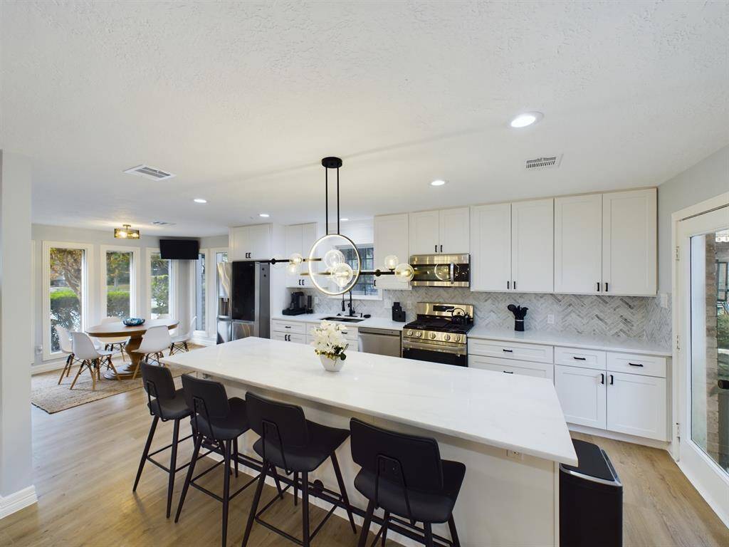 Spectacular Kitchen with Large Marble Slab Central Island, Countertops and Herringbone Backsplash