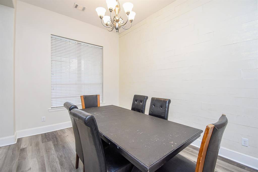 Enjoy elegant entertaining in a sophisticated formal dining room featuring a striking accent wall that adds depth and visual interest to the space.