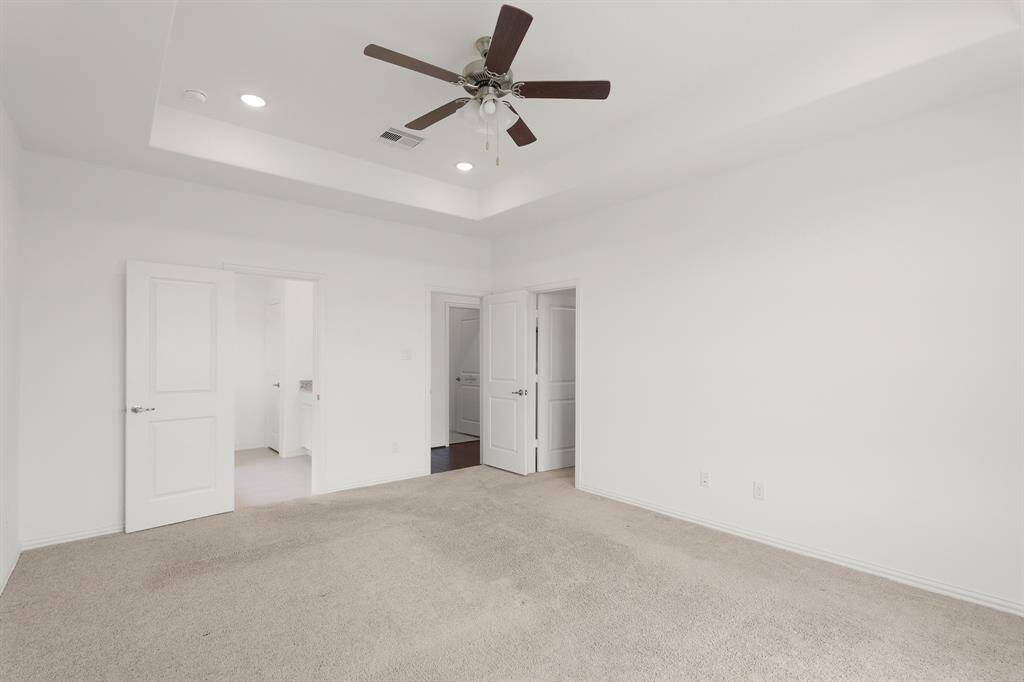 The spacious Primary Bedroom is a light and bright serene retreat with warm carpet, trey ceilings, and an En Suite Bathroom.