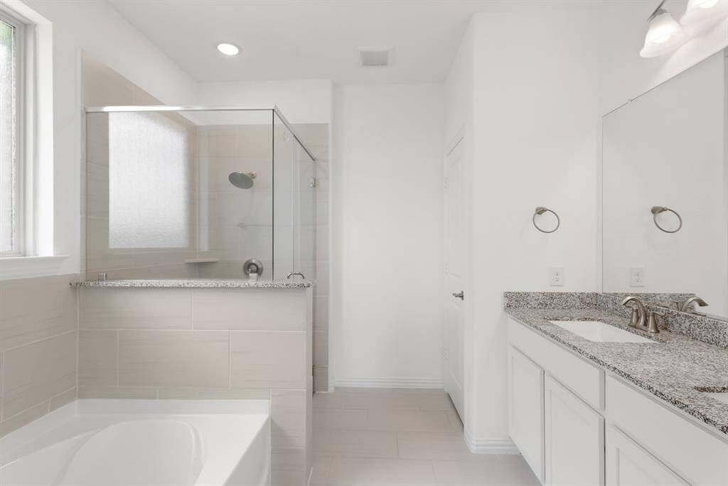 Spacious En Suite Primary Bath features a large walk-in shower, soaking tub, and a generous-sized walk-in closet.