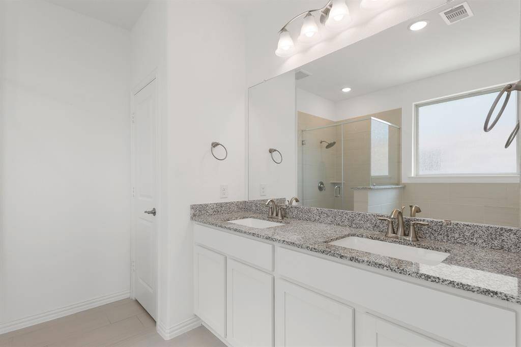 With dual sinks, spacious countertops, and sleek fixtures, the Primary Bathroom offers a fresh, contemporary feel.