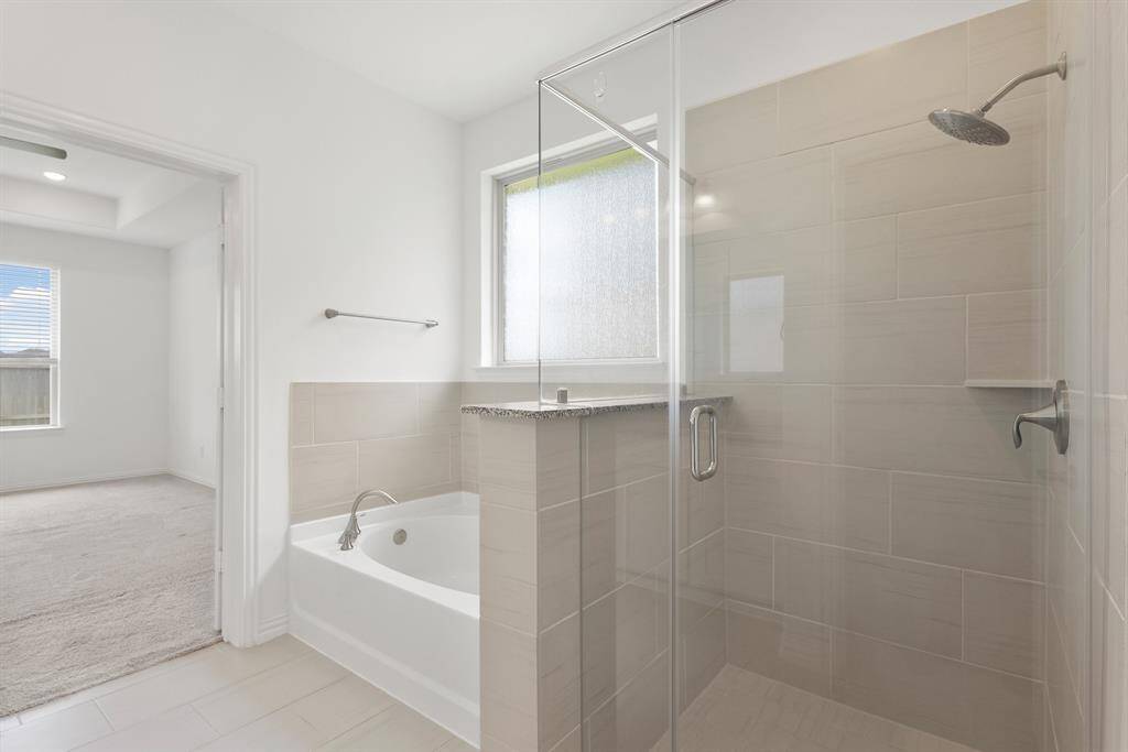 The sleek tiled Shower with contemporary finishes that adds style and function to the En Suite Bath.