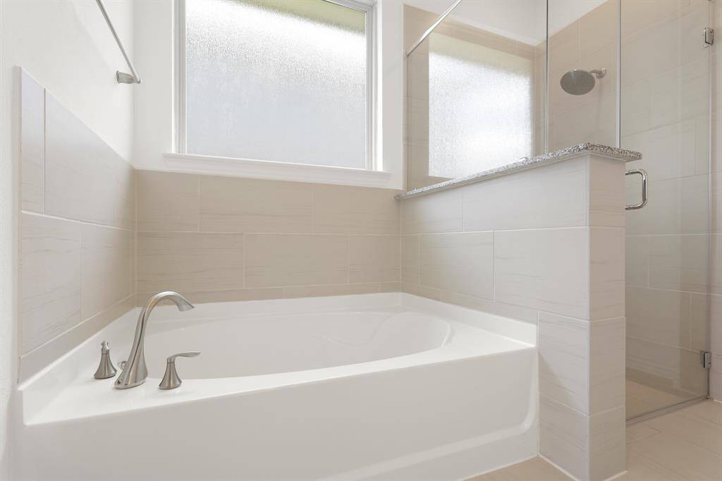 Unwind in a luxurious soaking tub, perfect for relaxing after a long day in a serene, spa-like setting.