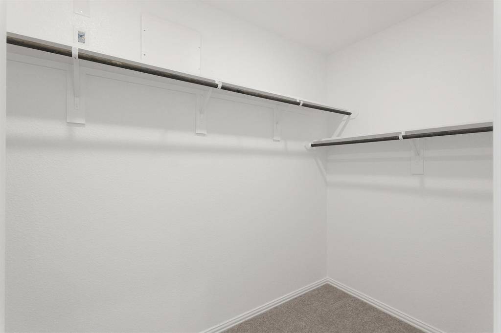 Expansive Primary Suite walk-in closet offers generous storage with built-in shelving and room to stay organized in style.