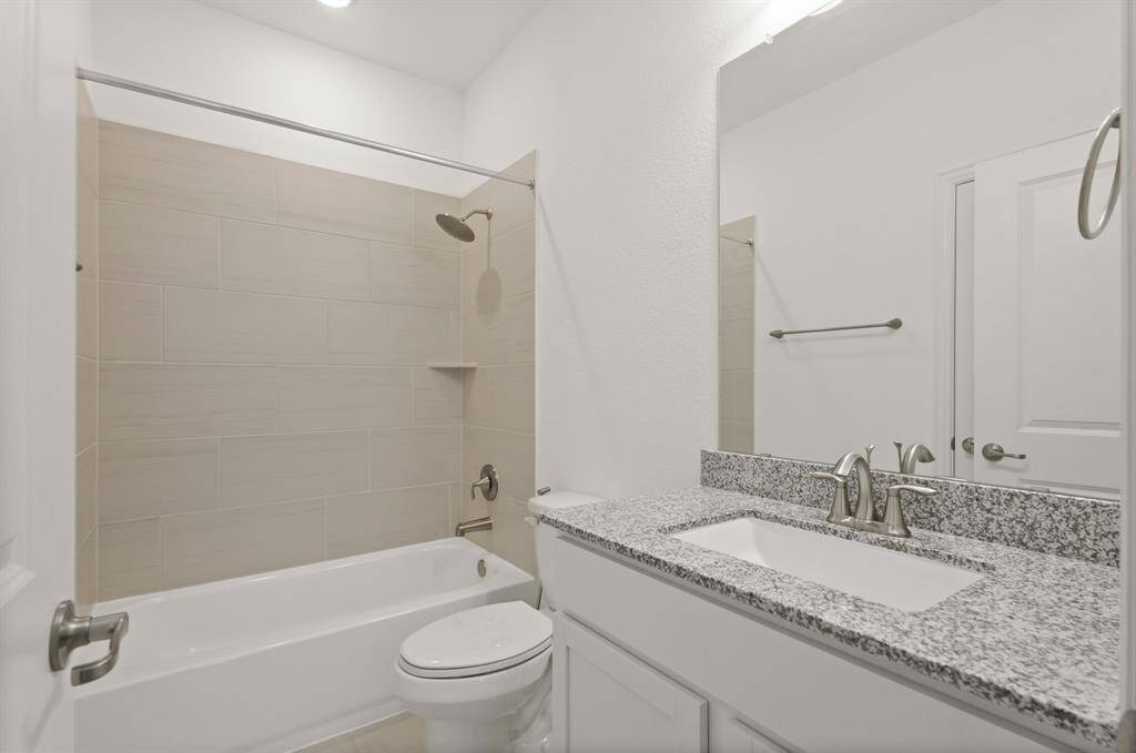 The bright Secondary Bathroom features a tub/shower combo, sleek vanity, offering comfort and functionality for family or guests.