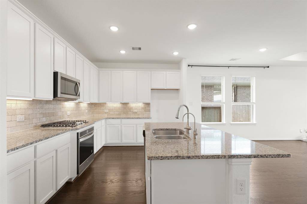 Enjoy the beauty and durability of granite countertops throughout the Kitchen, complemented by under-cabinet lighting. The large Island offers an alkaline filter water system, providing purified, mineral-rich drinking water straight from the tap.