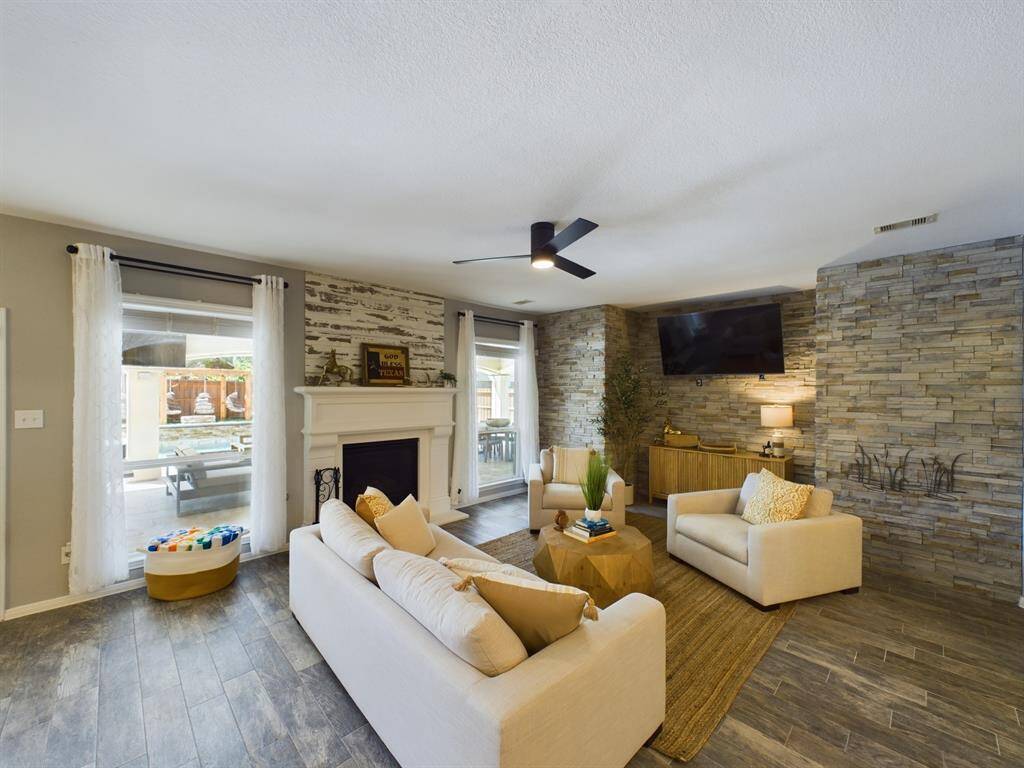 Family Room w Natural Stone Walls and Gas Log Fireplace w Views of the Backyard Retreat