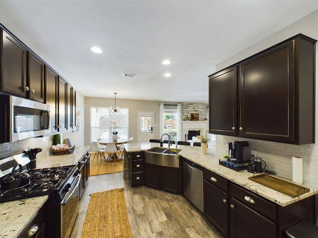 Beautiful Kitchen with Lots of Granite Counters, Ample Cabinets, Tile Backsplash and Under Cabinet Lighting