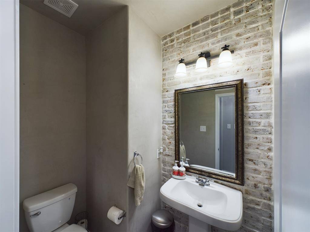 Half Bath off Family Room with Faux Plaster Walls and Accent Brick Wall
