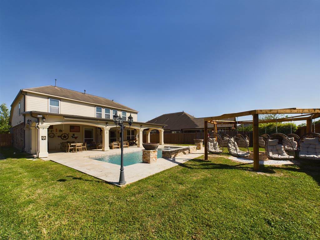 Sparking In-Ground Gunite Pool w/Water Features. Yard also features an outdoor shower, swinging chairs, firepit and 1/2 bath