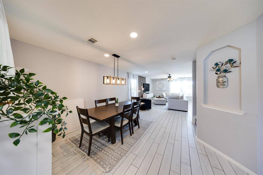 Spacious dining or receiving area with neutral tones and beautiful lighting, ideal for hosting dinners and family celebrations.
