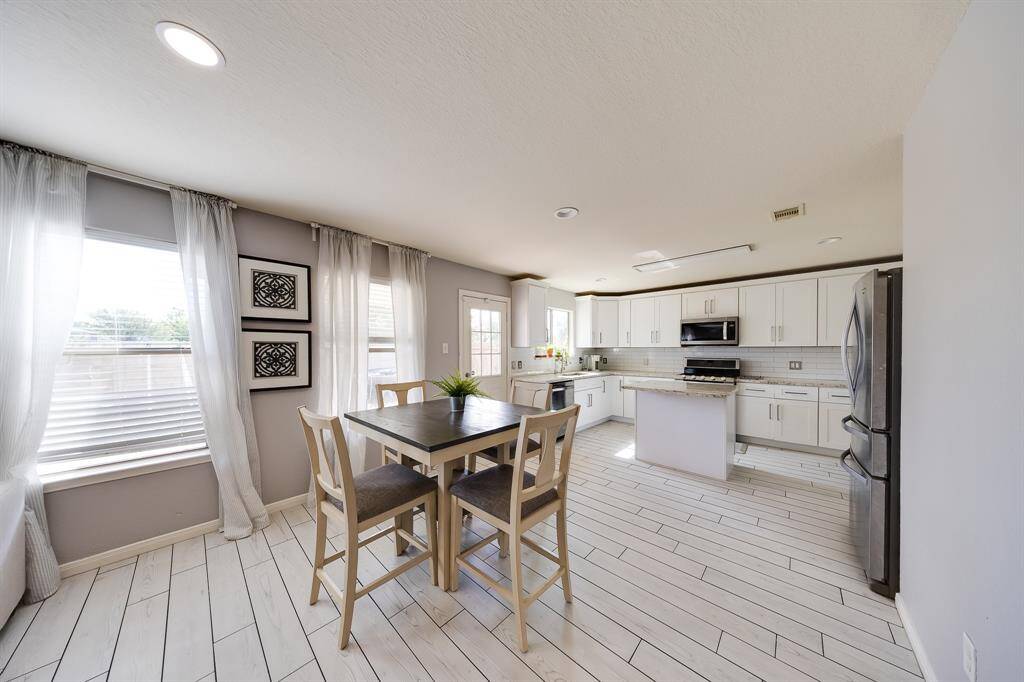 Spacious kitchen and breakfast combo with abundant natural light and seamless flow to backyard patio.