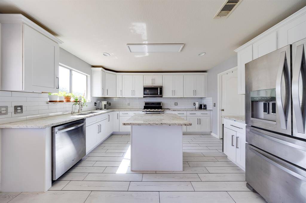 Bright kitchen layout with window views, ample cabinetry, and gas stove—perfect for daily cooking.