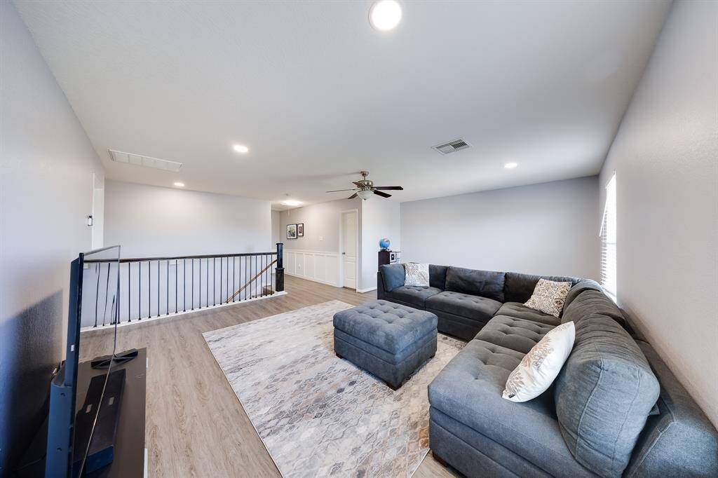 Spacious upstairs game room with natural light and neutral tones—perfect for a secondary living area.
