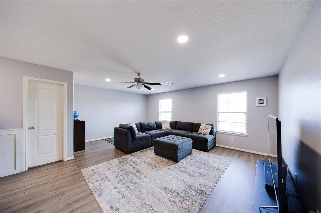 Alternate view of the loft showing full wall space and windows that bring in sunlight.