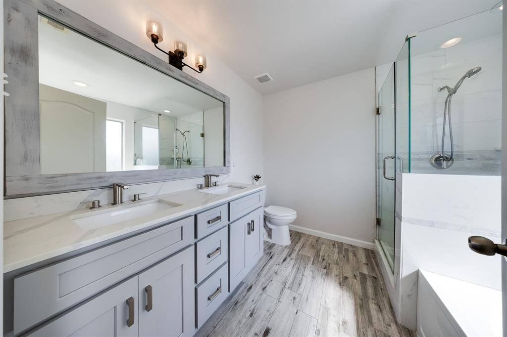 Beautiful double vanity bathroom with modern fixtures, elegant cabinetry, and a large framed mirror.