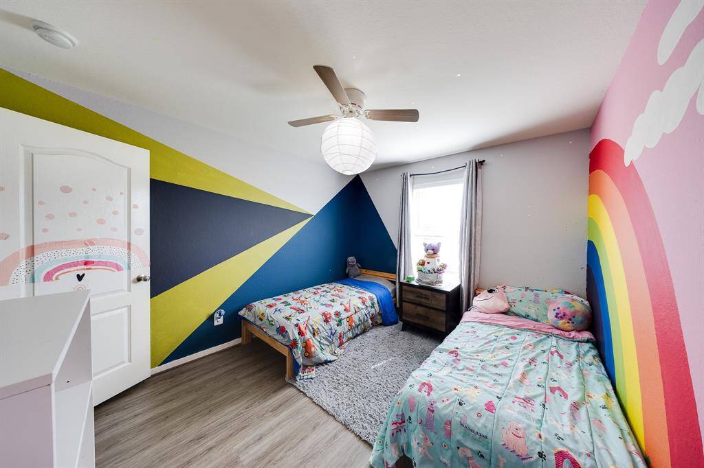 Colorful children’s bedroom with geometric and rainbow wall art—fun and inviting.