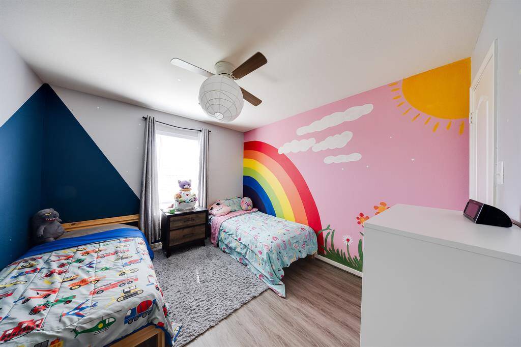 Cheerful kids’ room with rainbow mural, sun detail, and natural light.