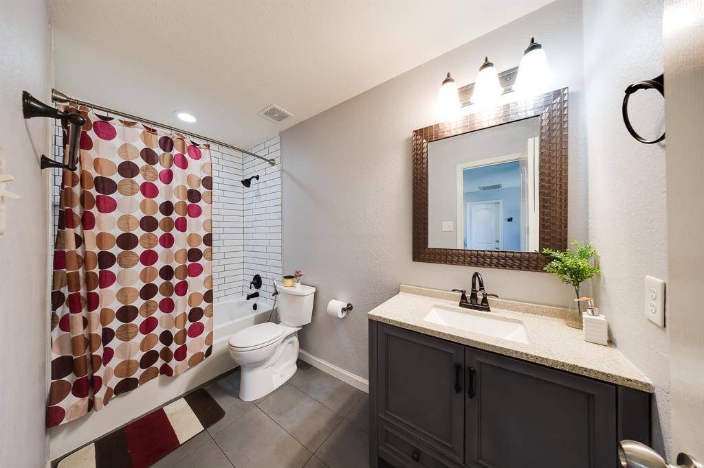 Second bathroom with subway tile shower, modern fixtures, and stylish vanity.