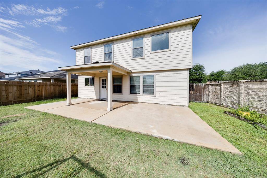 Backyard view with full exterior of home and covered patio—ample space for entertaining or adding a play set.