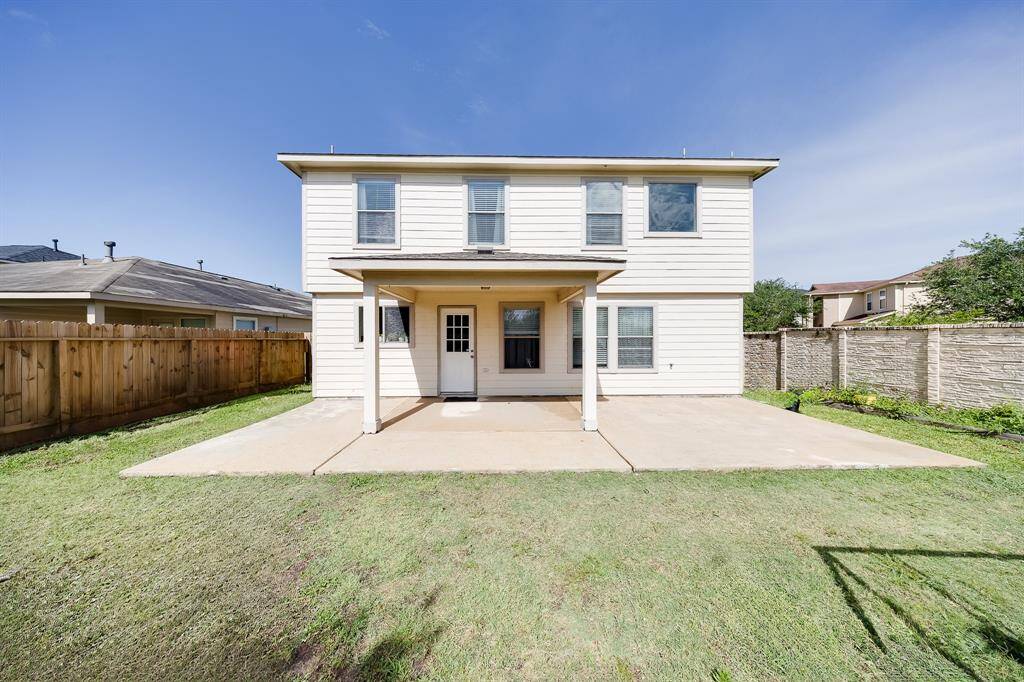 Full rear elevation shows extended patio deck and privacy fence, perfect for enjoying your backyard.
