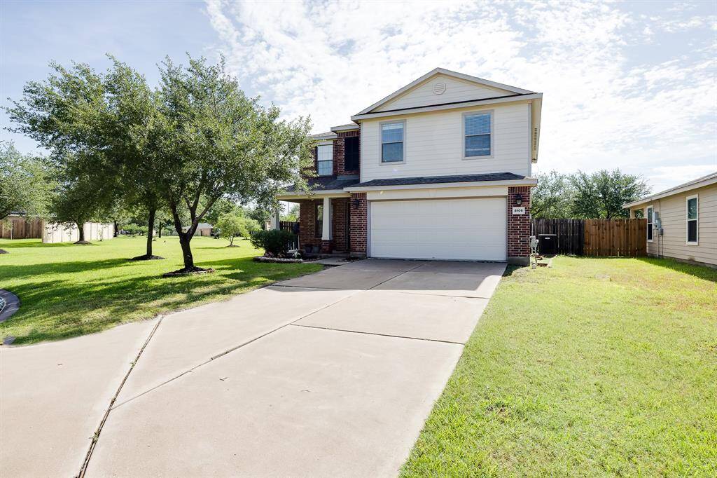 Long driveway fits multiple vehicles comfortably, leading to a clean and inviting brick-accented entrance.