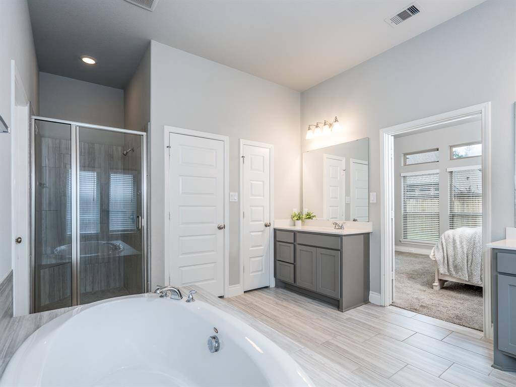Primary bath has two quartz vanities plus a separate tub and shower.