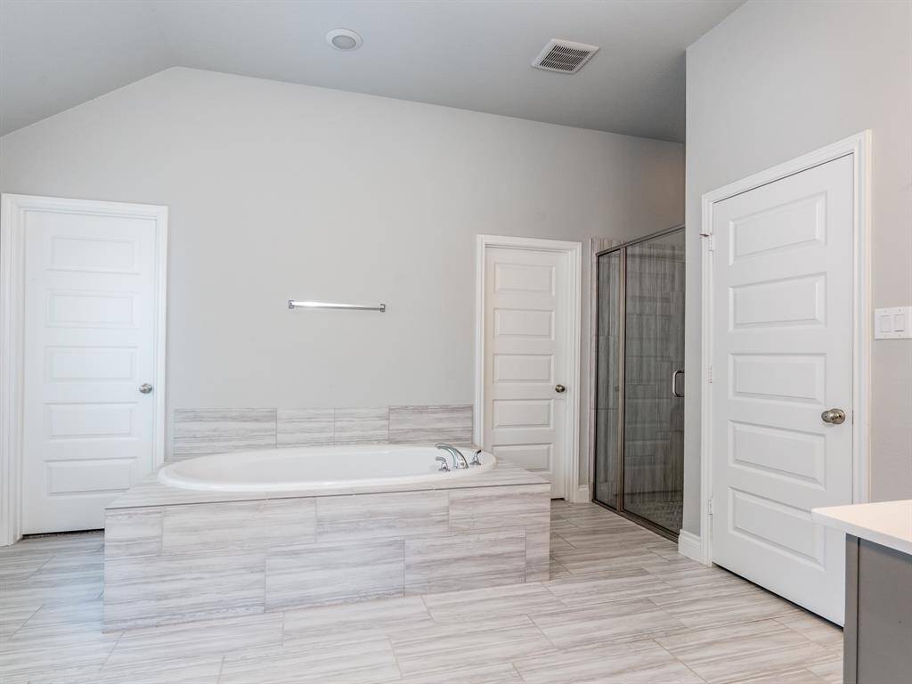 Large bath features 2 closets and a soaking tub.