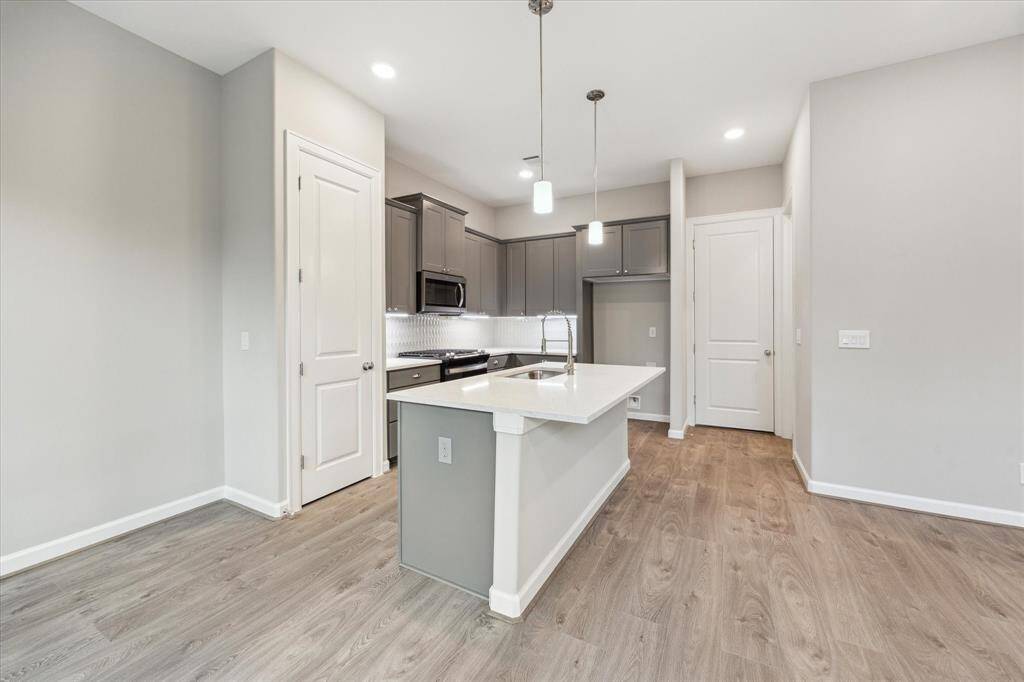 Central island with seating and under-cabinet lighting offers a stylish hub for entertaining or casual meals.