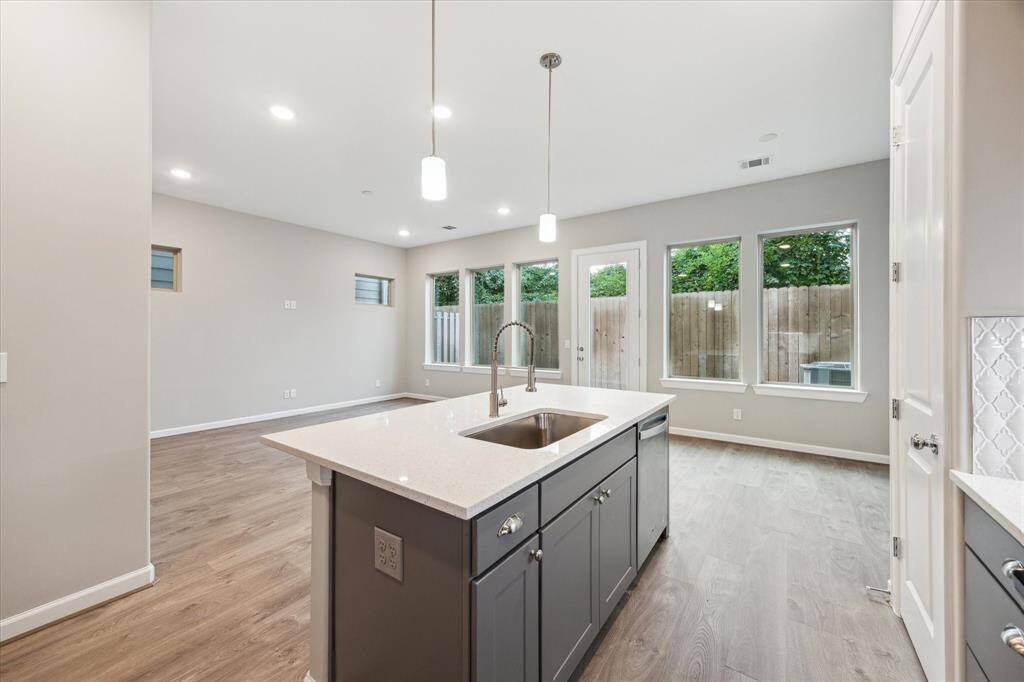 Additional view of the kitchen showcasing the expansive center island with bar seating, pendant lighting, and deep single-basin sink.