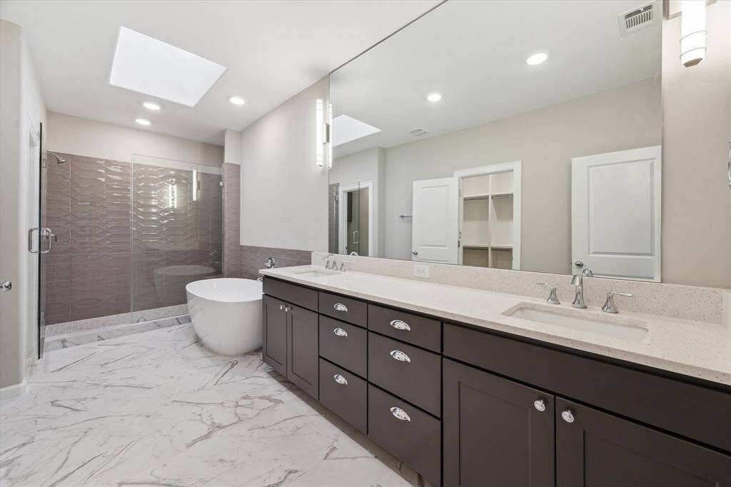 Frameless glass shower with textured designer tile for a luxurious, modern feel.