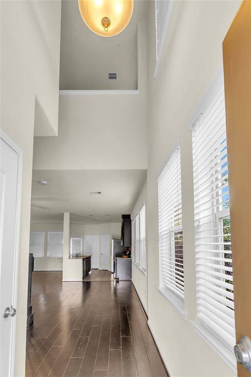 The beautiful entrance of the home features high ceilings, with tall windows on the right side and additional windows above!