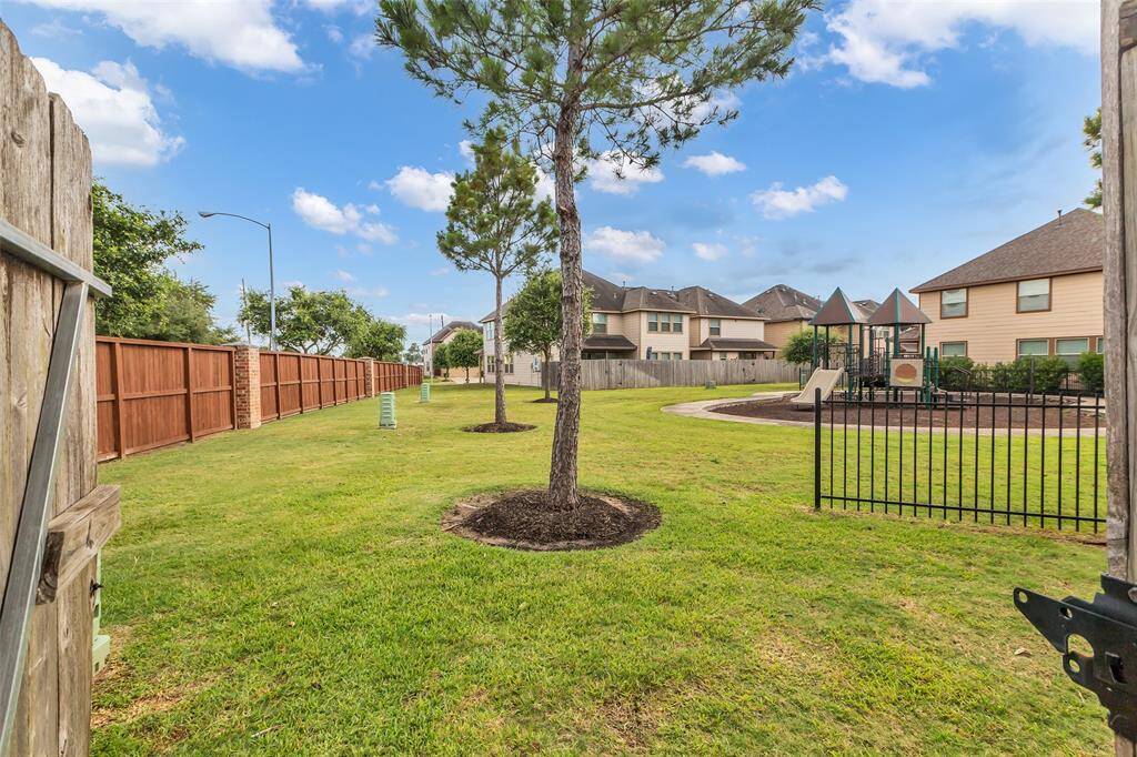 The backyard features a porch perfect for relaxing and entertaining, with direct access through the fence to an open park located on the right side of the home