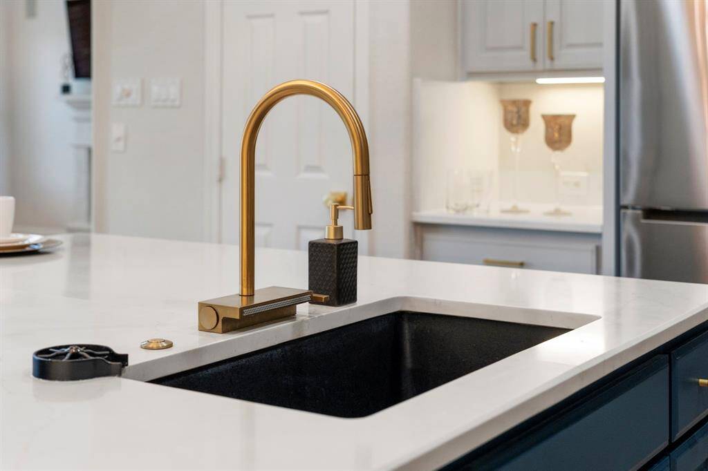 The kitchen sink also has a modern brushed gold fixture.