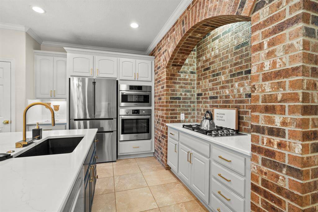 The brick accent wall surrounds the gas cooktop.