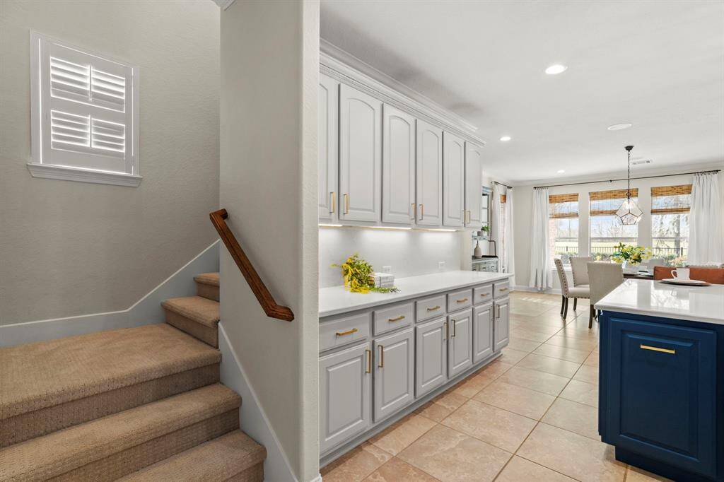 The kitchen features plenty of storage space and is next to the additional staircase to the second floor.