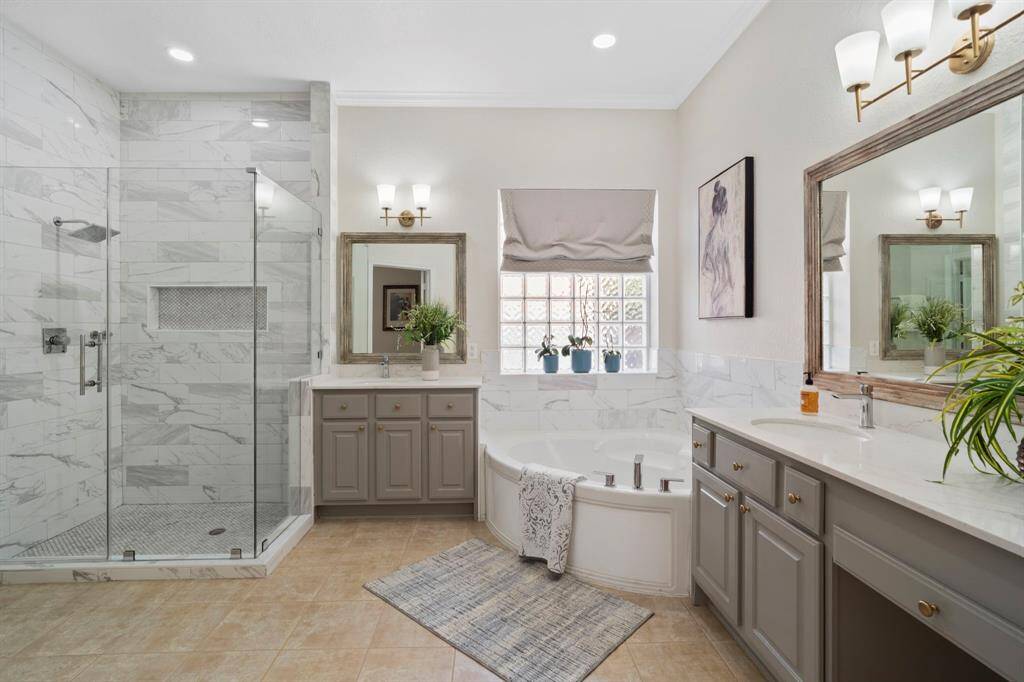 The primary bathroom also has a walk-in shower with glass door and tile surround.