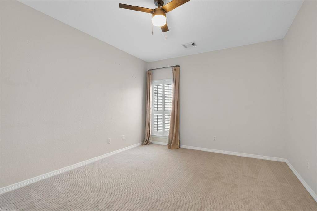 Third bedroom features awindow, ceiling fan, and plush carpet.