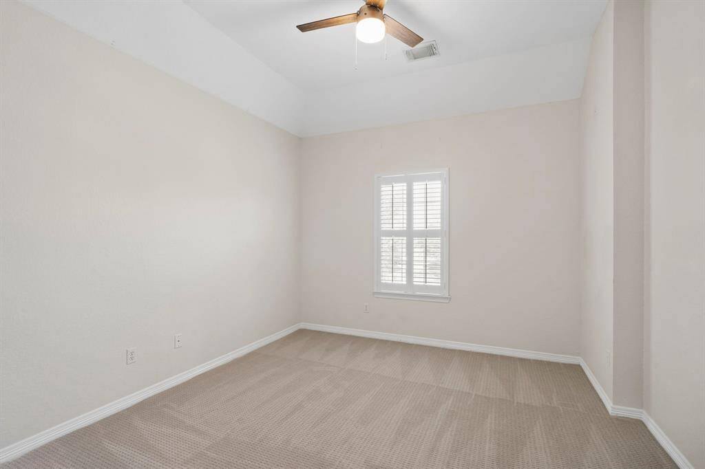 Fourth bedroom features awindow, ceiling fan, and plush carpet.