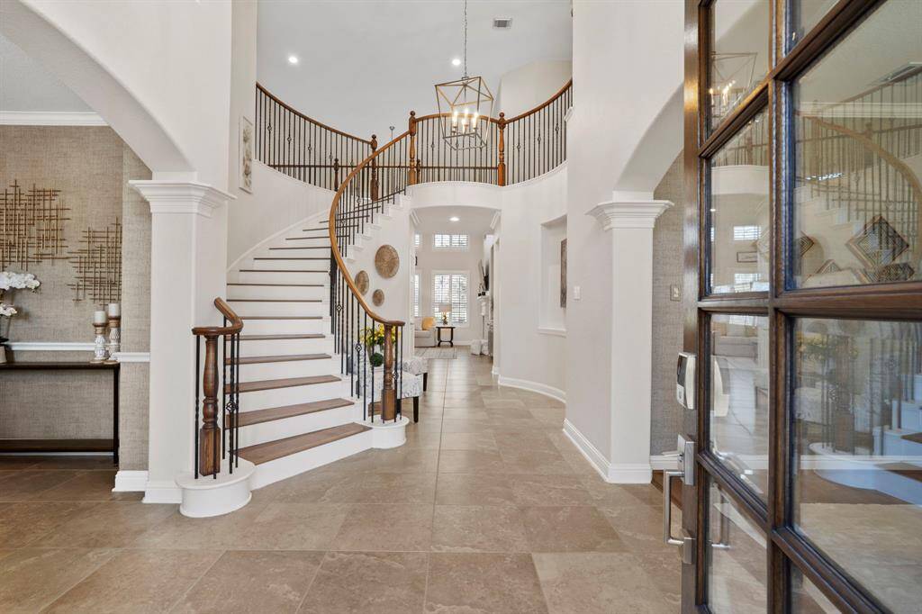 Upon entering the home hashigh ceilings, archways, tile floors, staircase to the second floor, chandelier, and recessed lighting.