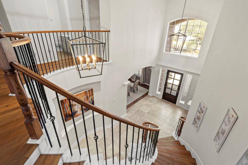 The curved staircase to the second floor has iron railing details.