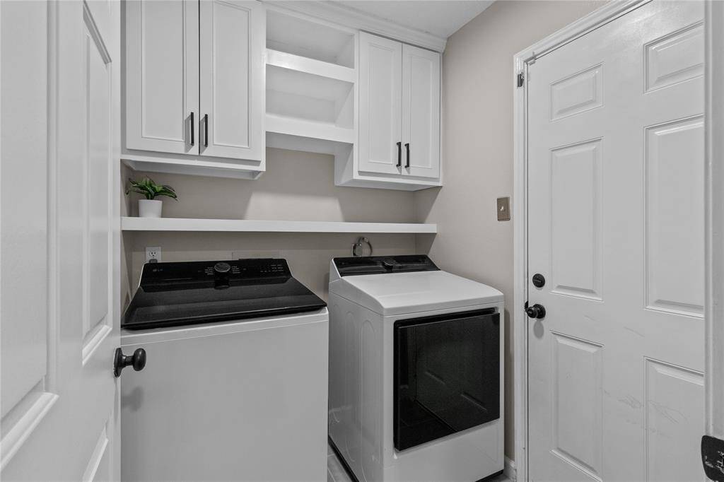 Say hello to practical design! Upper cabinets and floating shelves keep this laundry space organized and tidy.