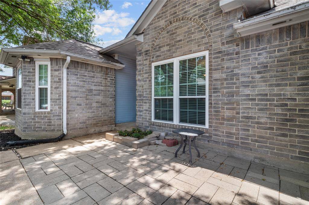 Enjoy morning coffee or evening chats on your spacious front paver patio under the oaks.