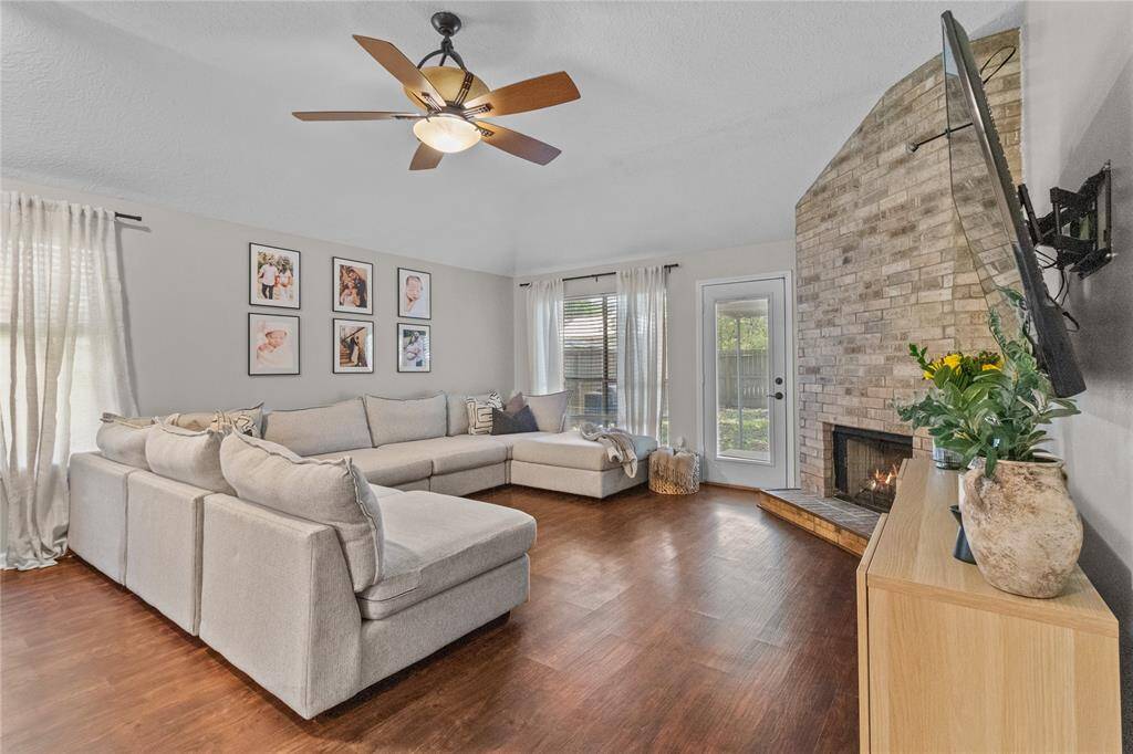Gather around the cozy gas fireplace in this oversized living room with vaulted ceilings and backyard access.